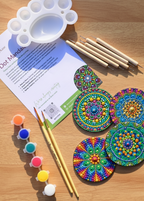 Dot mandala coaster painting kit with 4 MDF wooden coasters, 5 dotting tools, 6 acrylic paints and stencils arranged on a wooden surface - Arttykase Indian folk art DIY