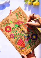 ands painting a vibrant Madhubani bird folk art design in progress on a pre-etched A4 MDF wooden board - colorful birds, flowers and leaves in traditional Indian folk art style - Arttykase DIY painting kit