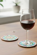 Wine glass resting on a finished hand-painted dot mandala coaster with vibrant Indian folk art geometric pattern on a wooden table - Arttykase